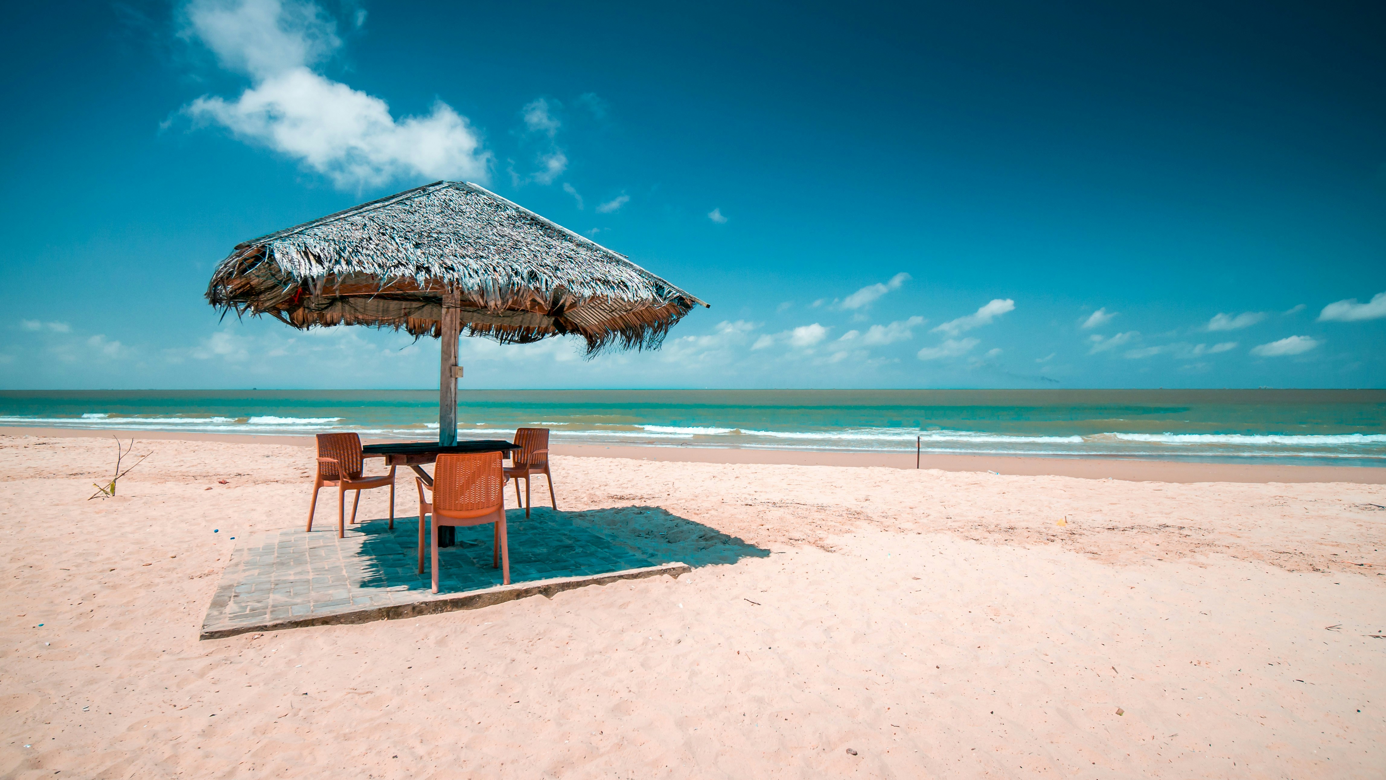 brown wooden beach lounge chairs on beach during daytime
