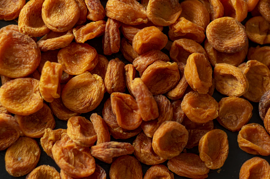 Whole dried apricots laid close on a dark bench