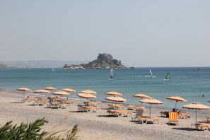 brown wooden beach lounge chairs on beach during daytime