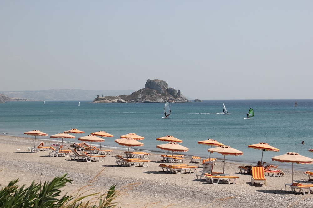 Sillones de playa de madera marrón en la playa durante el día