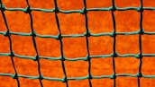 Close-up of high-quality safety net material stretched tightly on a sports field.
