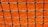 A close-up view of a green net with square openings set against a bright orange background. The net is neatly tied with visible knots, creating a grid-like pattern.