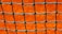 A close-up view of a green net with square openings set against a bright orange background. The net is neatly tied with visible knots, creating a grid-like pattern.