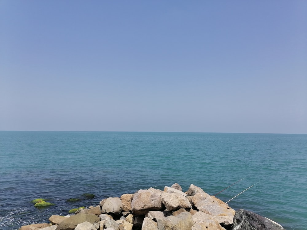 gray rocks near body of water during daytime