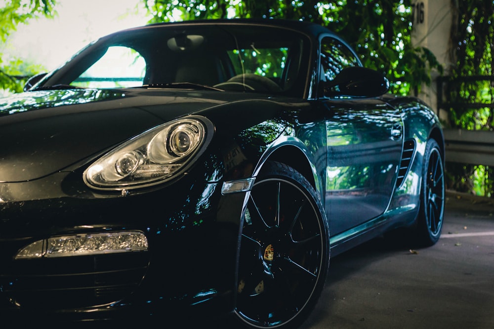 Porsche 911 preto estacionado em pavimento cinza