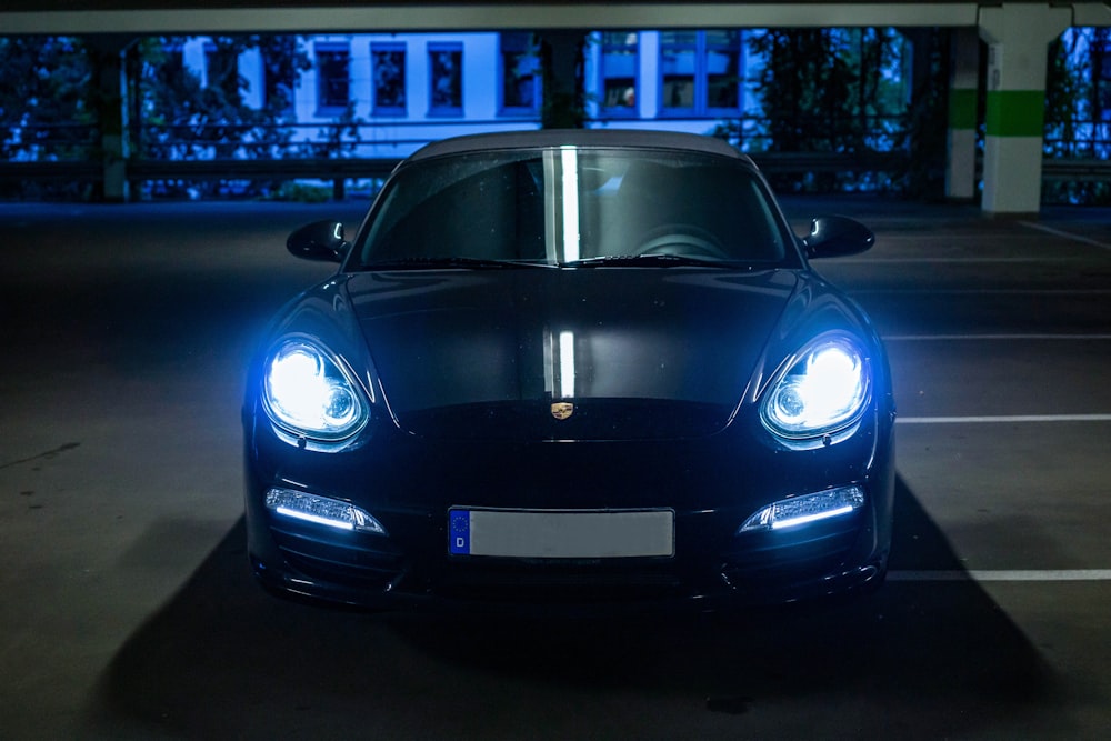 Schwarzer Porsche 911 nachts auf Parkplatz geparkt