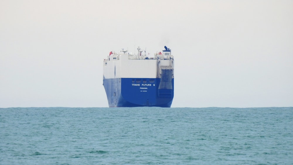 blue and white ship on sea during daytime