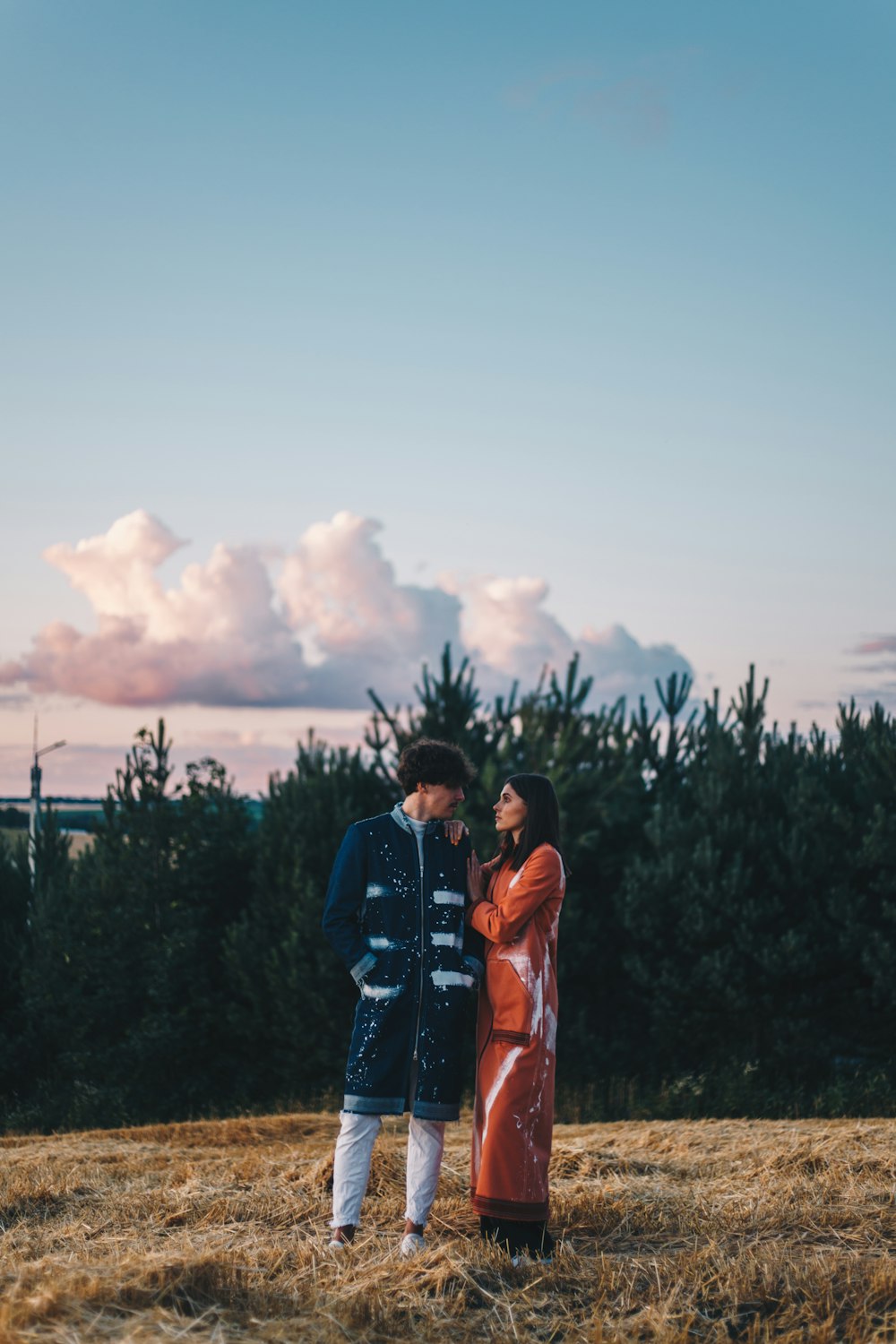 man and woman standing on green grass field during daytime