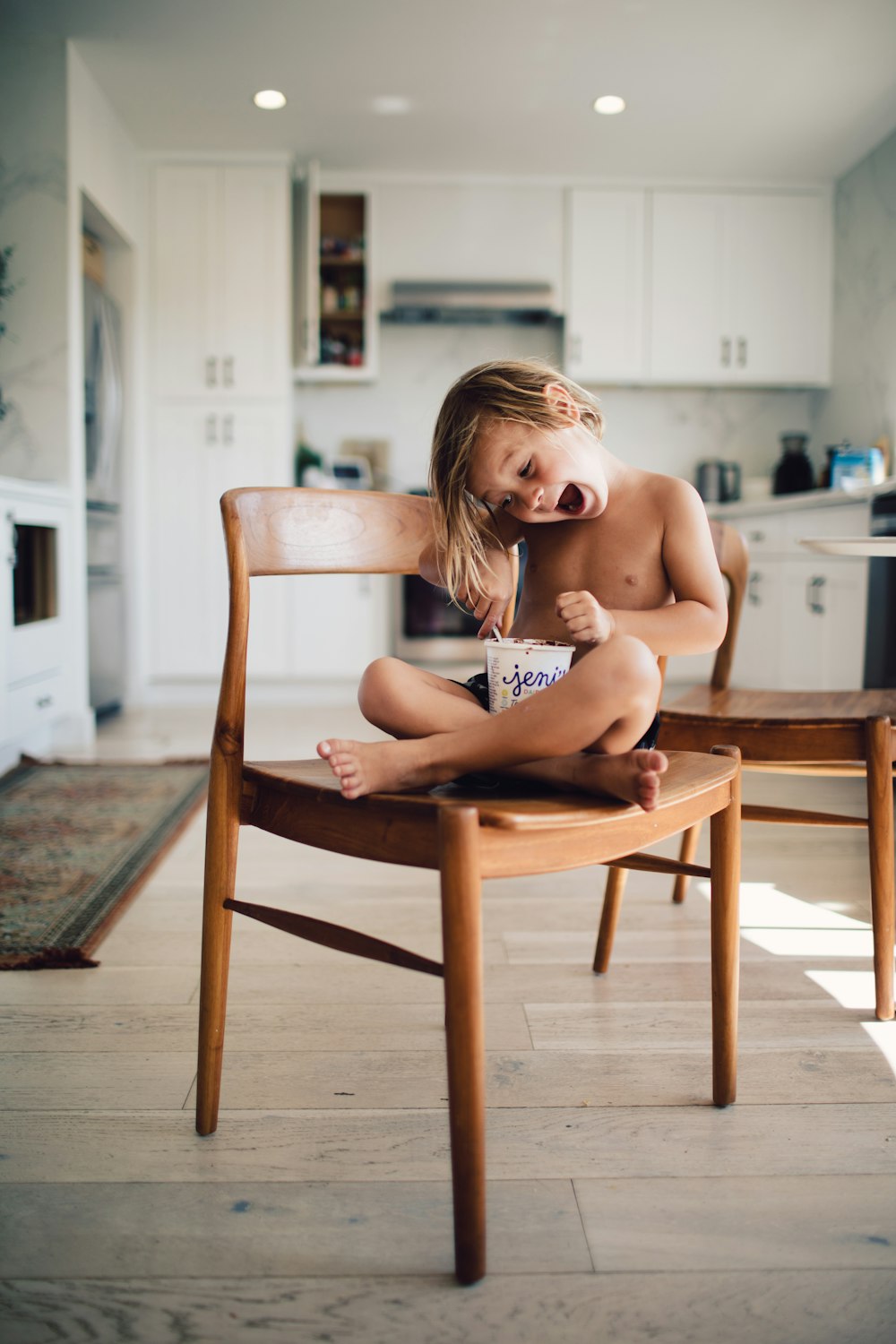 topless woman sitting on brown wooden chair