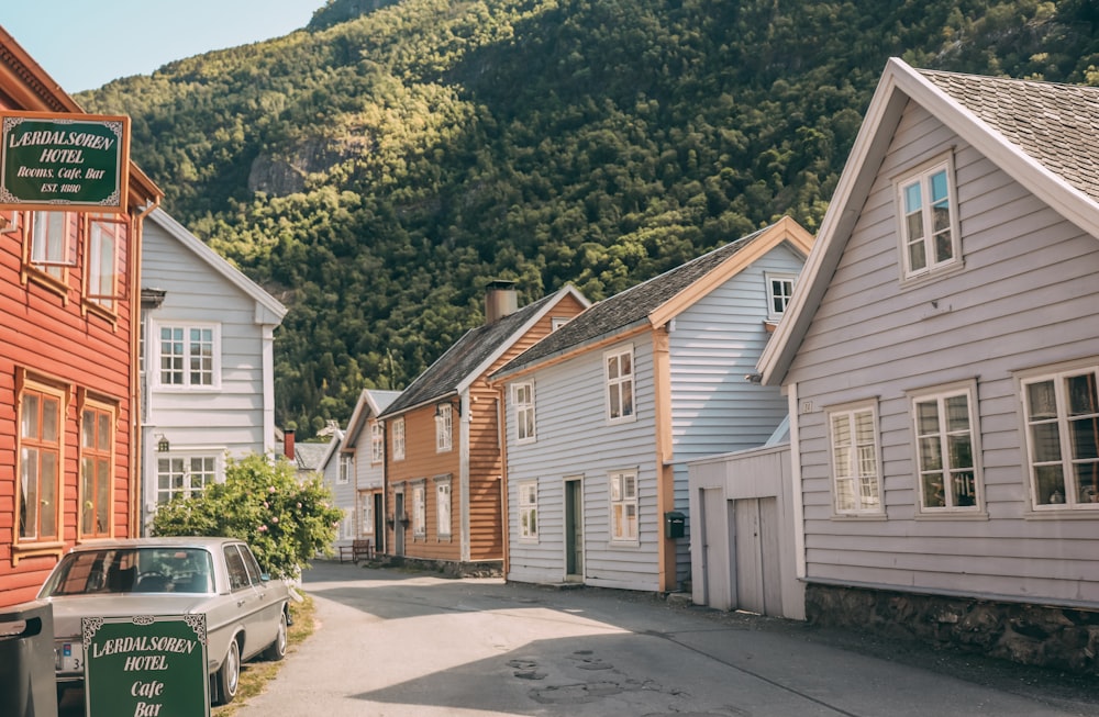 white van parked beside white and brown wooden house during daytime