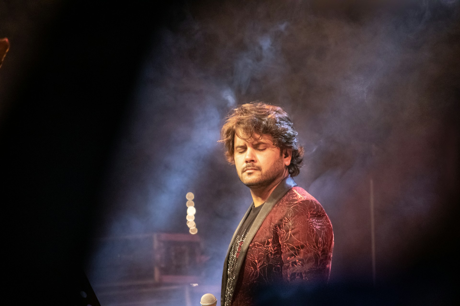 Yasmin Dream in a serene moment, studio microphone in front, eyes closed, feeling the music deeply.