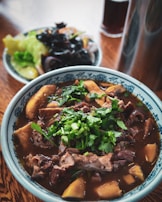 A bowl of richly textured beef spleen, surrounded by smaller cuts of heart and kidney.