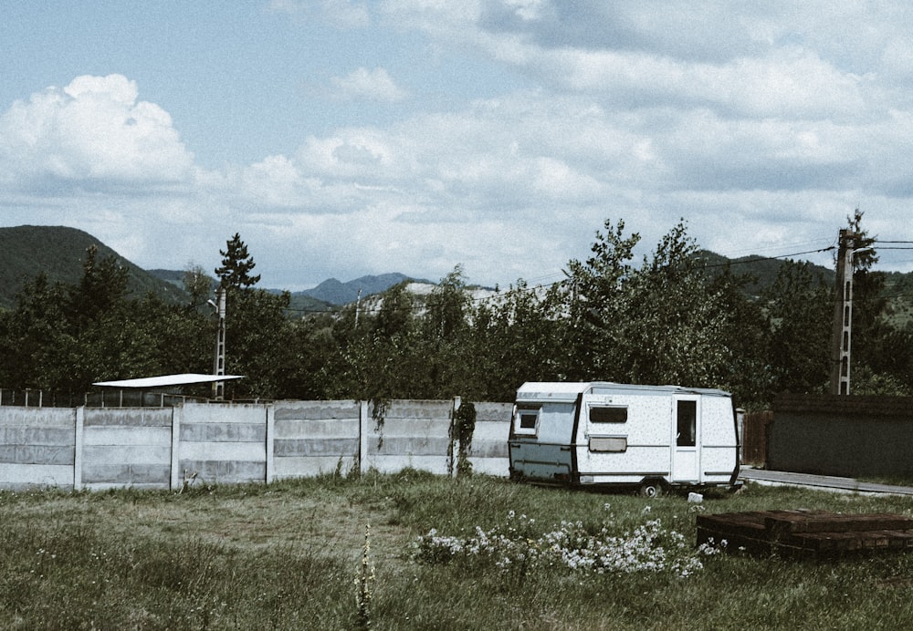white and gray rv trailer on green grass field during daytime