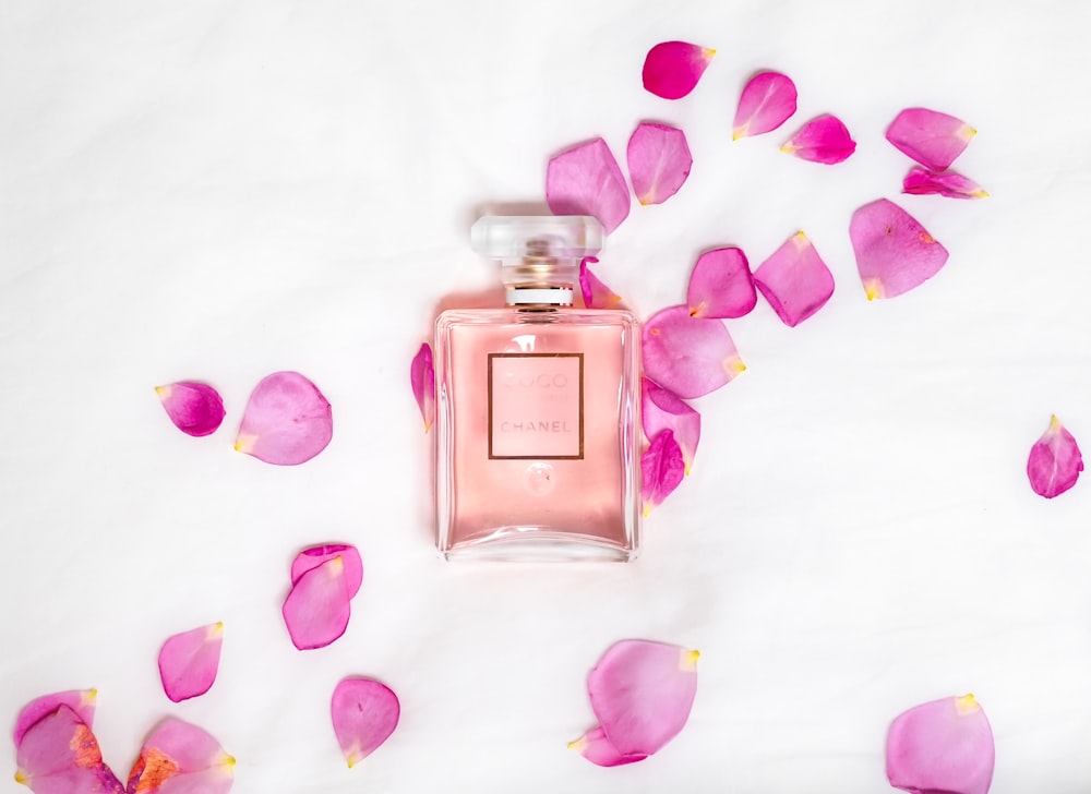 flacone di profumo con petali rosa