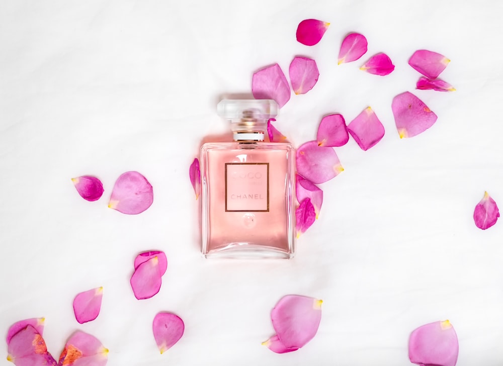 frasco de perfume com pétalas cor-de-rosa