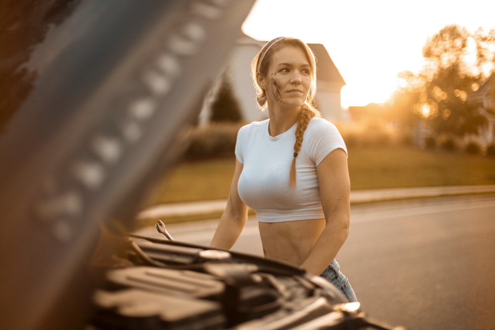 woman in white tank top and gray shorts holding a book