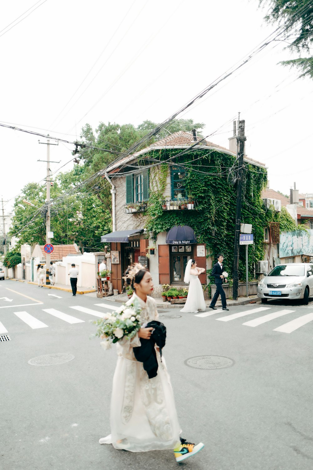 woman in white dress walking on street during daytime