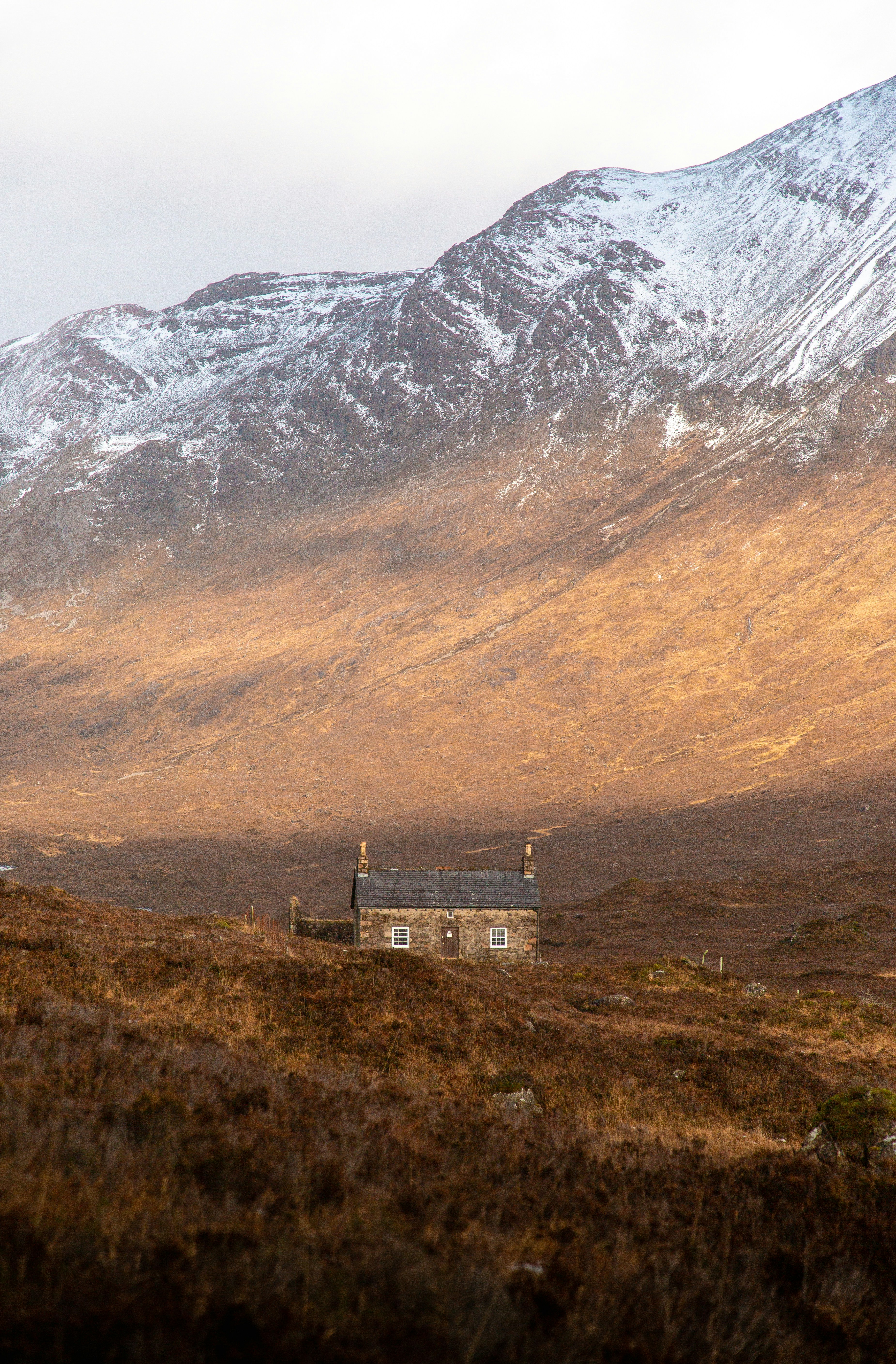 brown and white concrete building near mountain during daytime