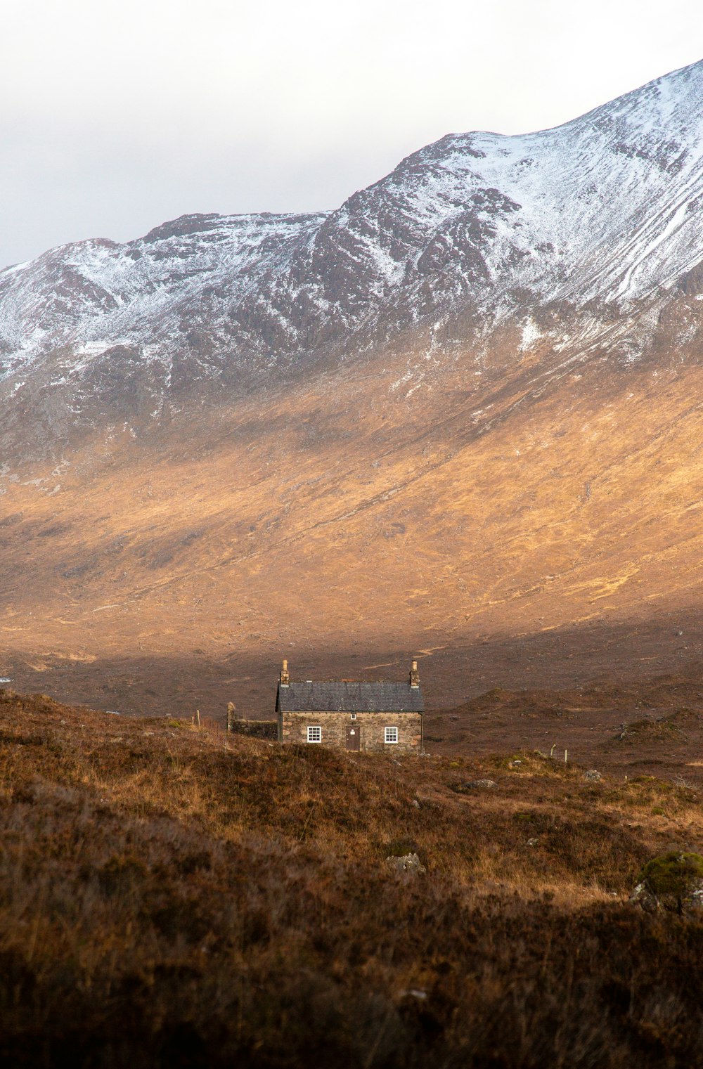 brown and white concrete building near mountain during daytime