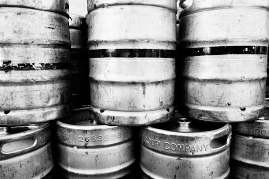 grayscale photo of barrels on wooden barrels