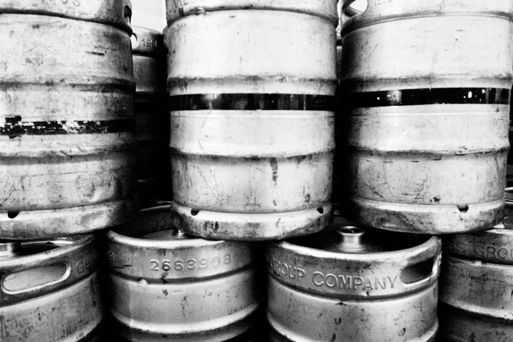 grayscale photo of barrels on wooden barrels