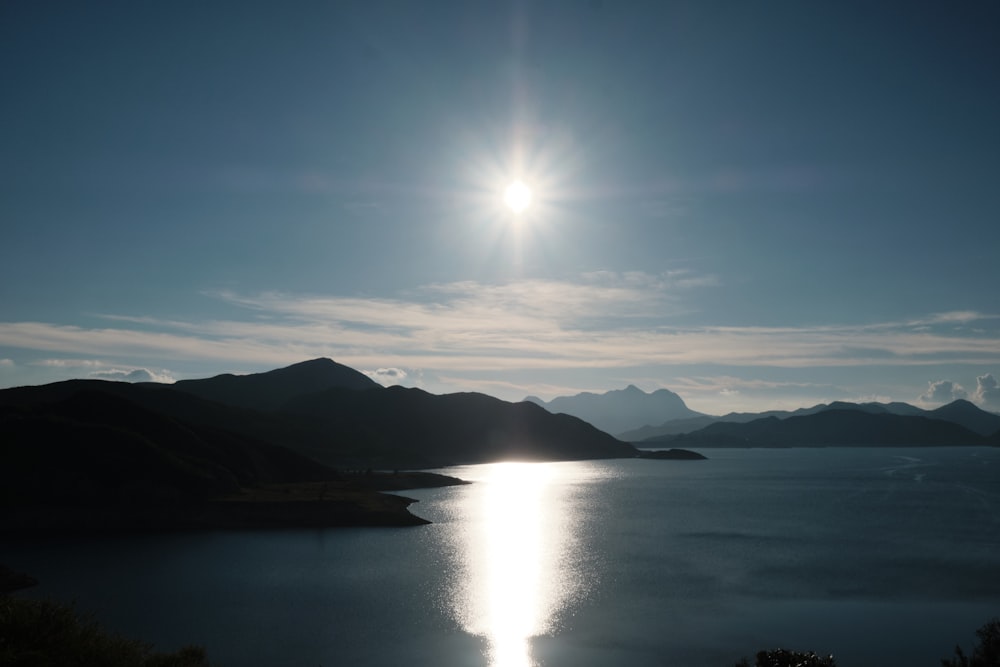 body of water near mountain under blue sky during daytime