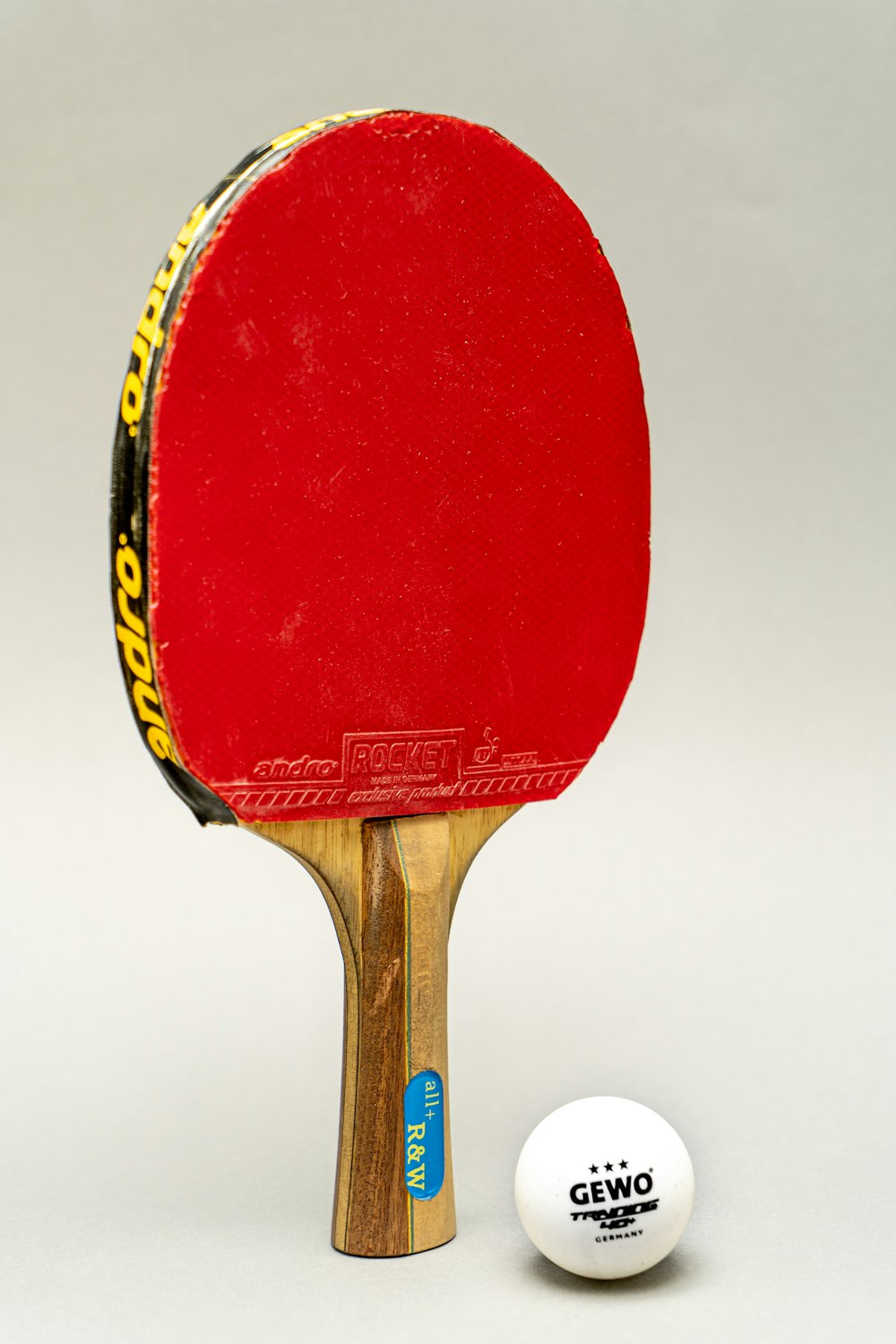 raquete de tênis de mesa de madeira vermelha e amarela