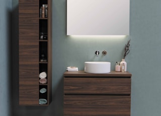 white ceramic sink beside brown wooden cabinet