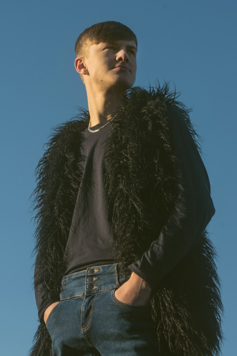 woman in black fur jacket and blue denim jeans