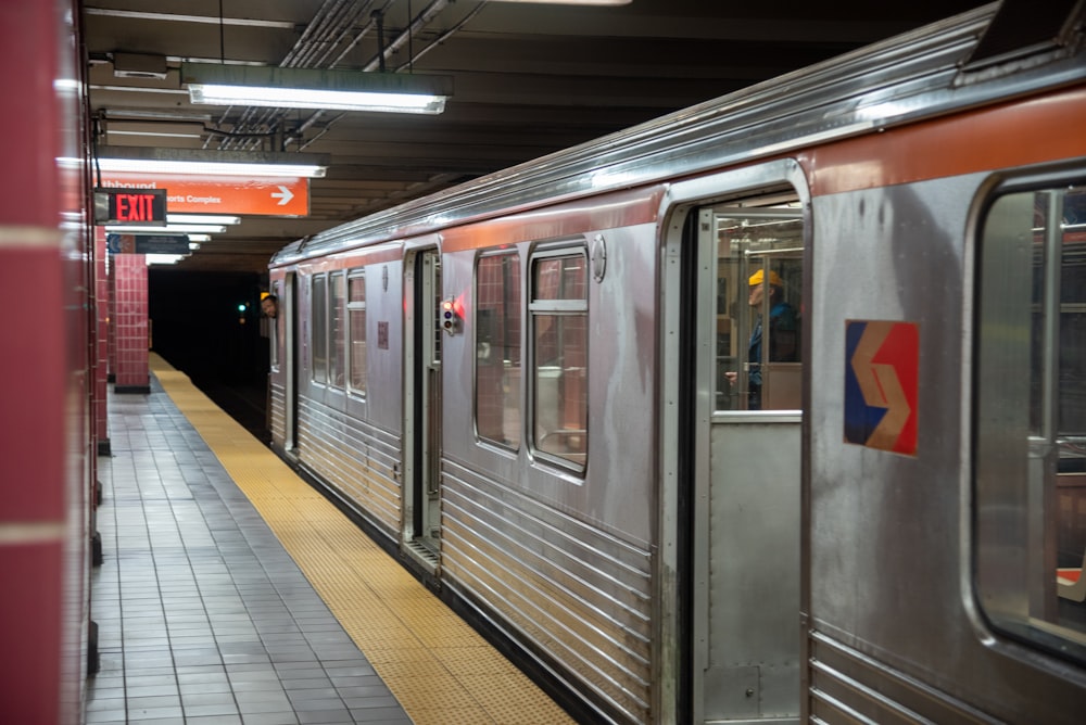 gray and red train in train station