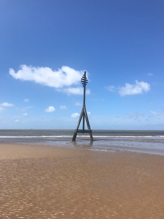 person standing on beach during daytime in Crosby Coastal Park United Kingdom