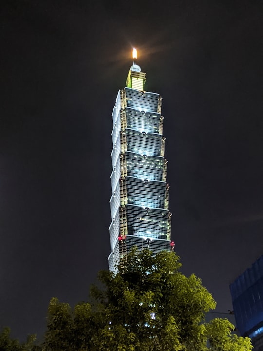 white and black tower during night time in Songshou Square Park Taiwan