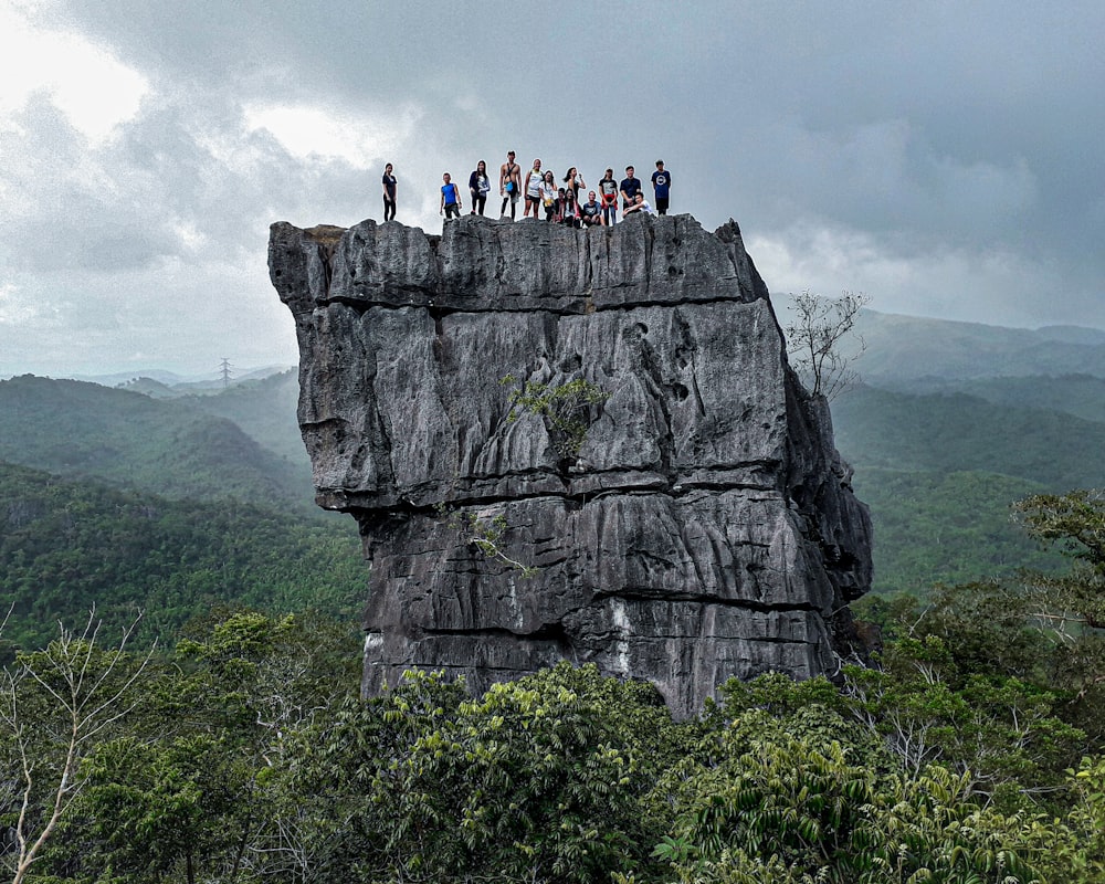 people climbing on rock formation during daytime