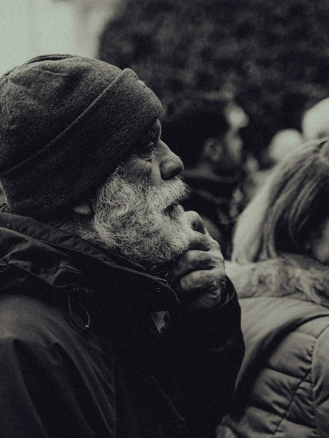 man in black hoodie kissing woman in black coat