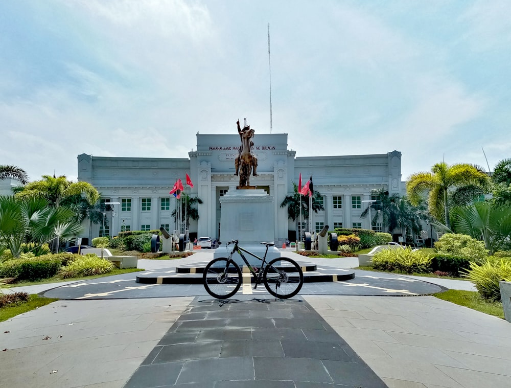 black bicycle parked near white concrete building during daytime