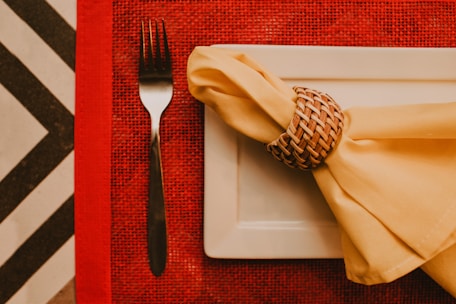 stainless steel fork and bread knife on white ceramic plate