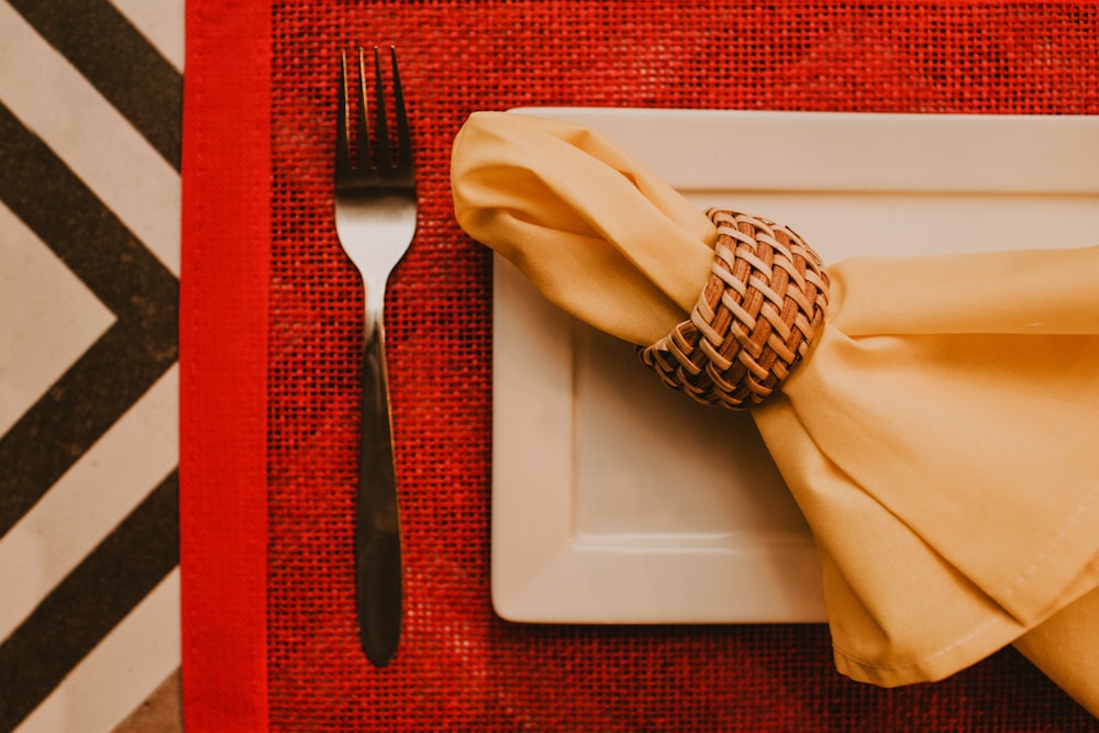 stainless steel fork and bread knife on white ceramic plate