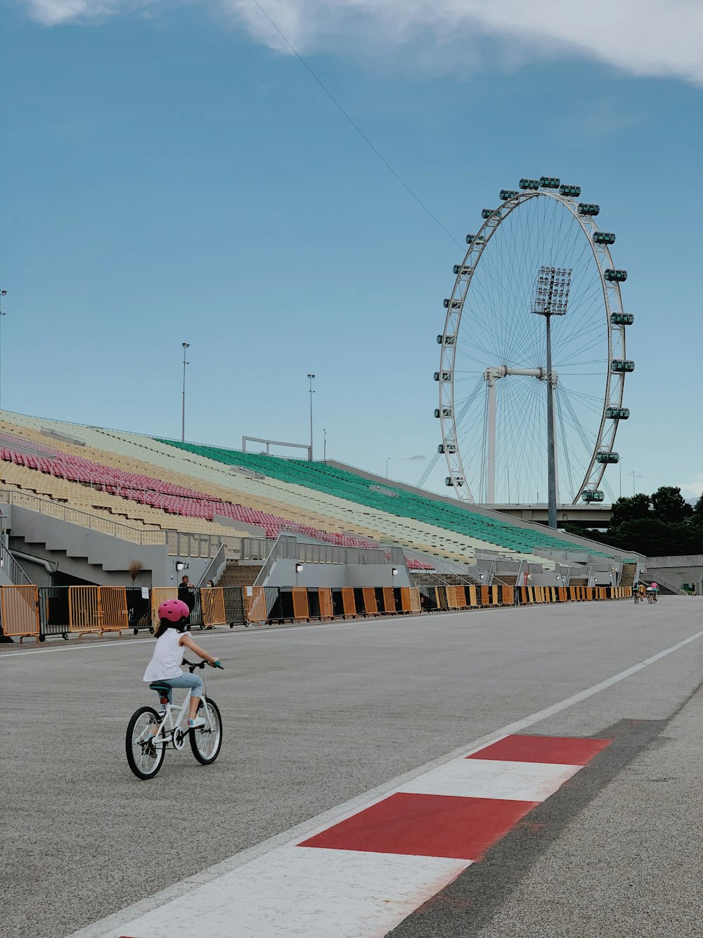 man in white shirt riding bicycle on gray concrete road during daytime