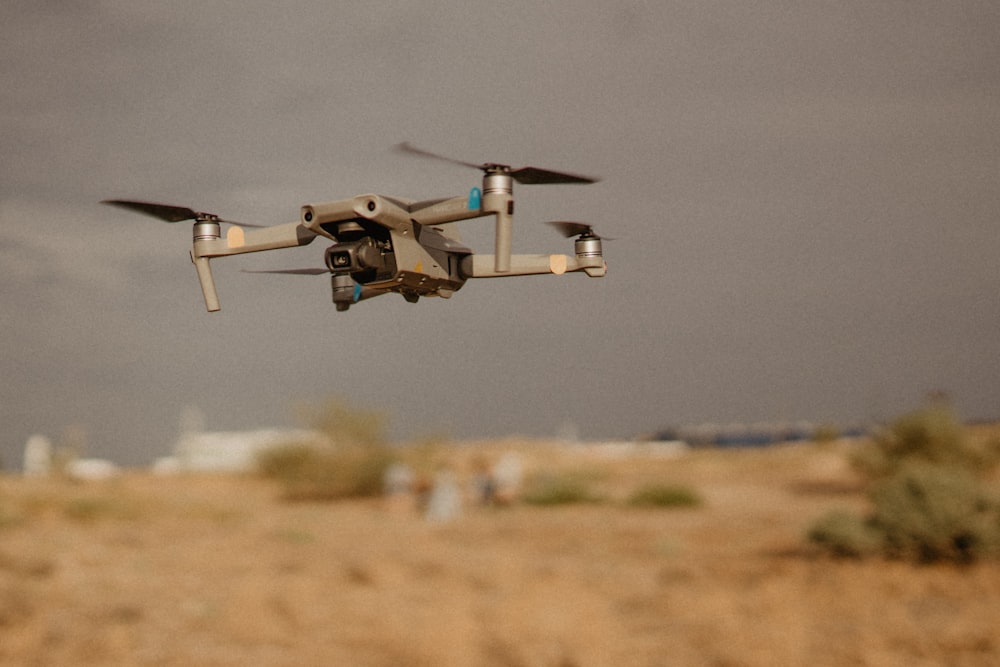 white and black drone flying in mid air during daytime