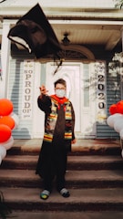 A happy adult student celebrating their graduation at home.