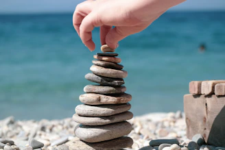 person holding stack of stones