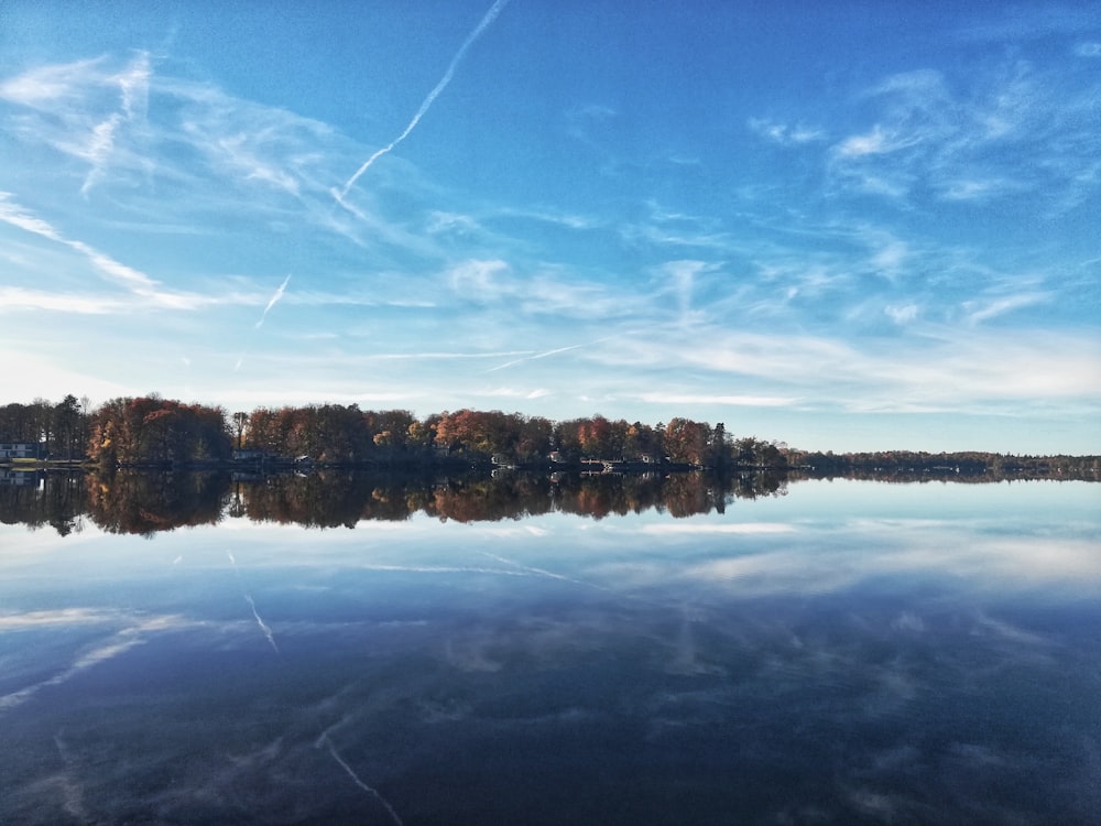 brown wooden dock on lake under blue sky during daytime