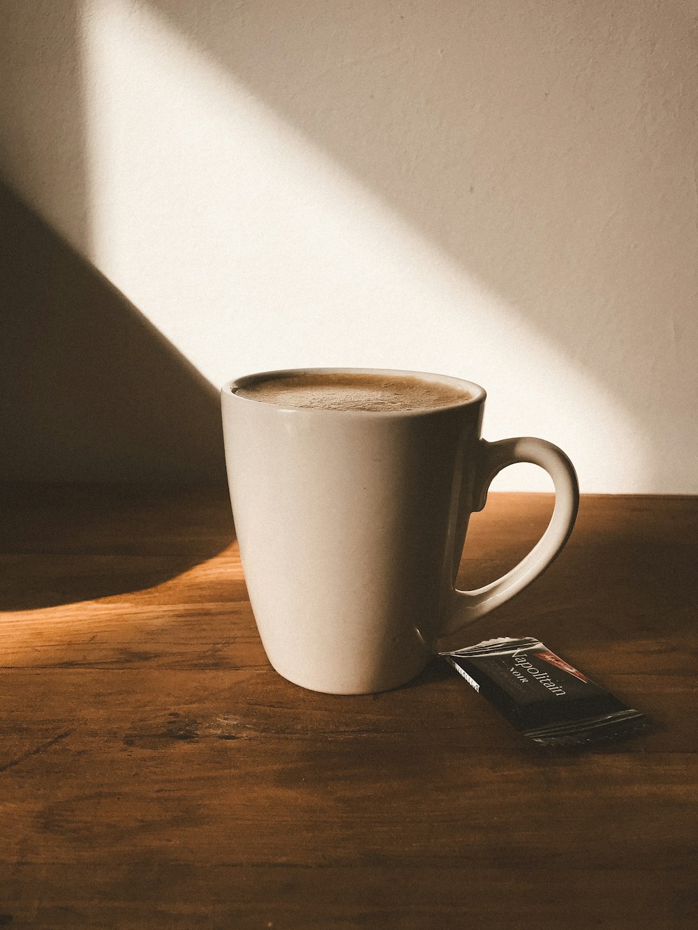 white ceramic mug on brown wooden table