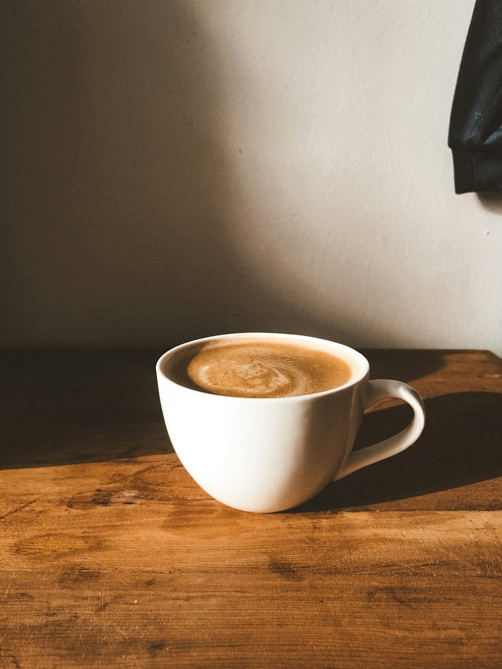 white ceramic mug on brown wooden table