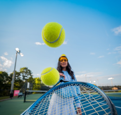 woman in black jacket and black pants holding tennis racket under blue sky during daytime