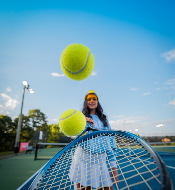 woman in black jacket and black pants holding tennis racket under blue sky during daytime