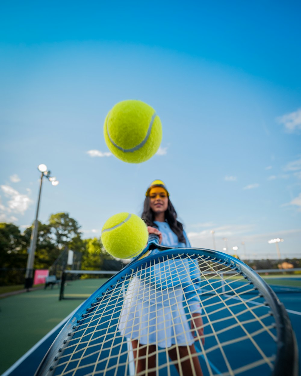 woman in black jacket and black pants holding tennis racket under blue sky during daytime