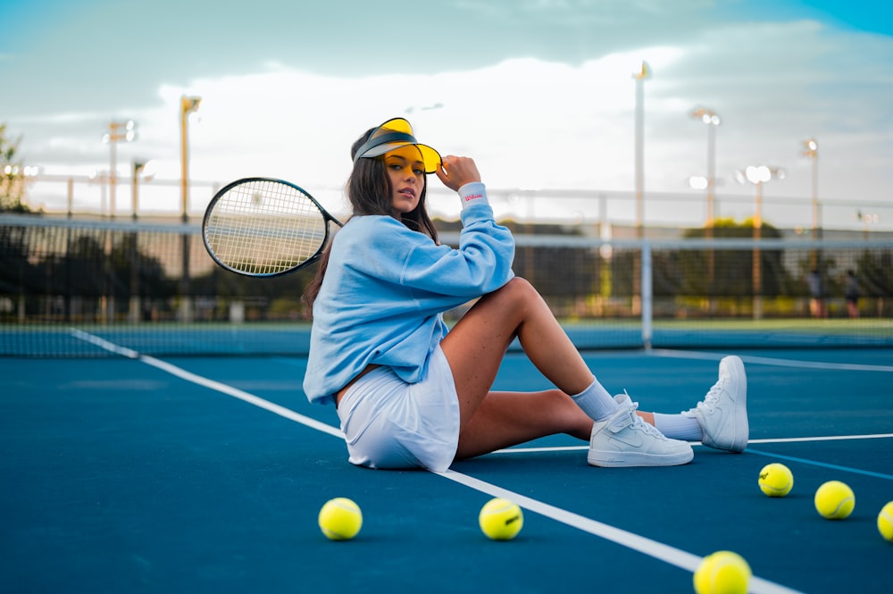 Mujer en vestido azul sentada en la cancha de tenis