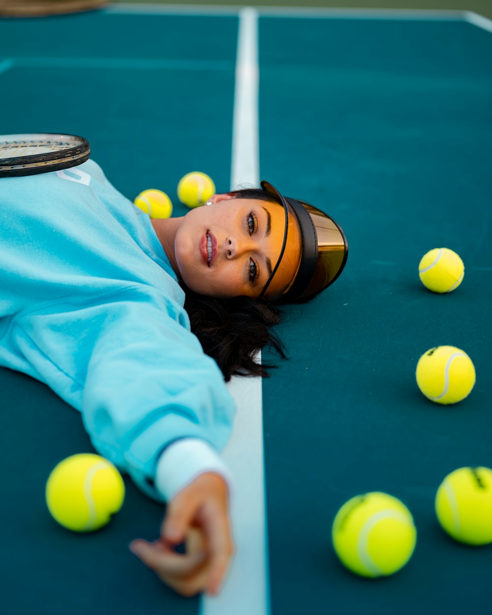 woman in teal long sleeve shirt lying on green billiard table