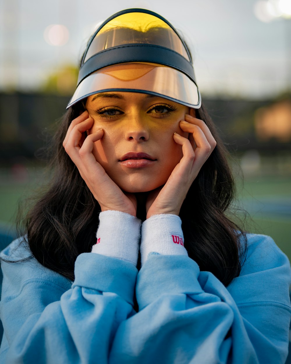 woman in blue long sleeve shirt wearing brown and white cap